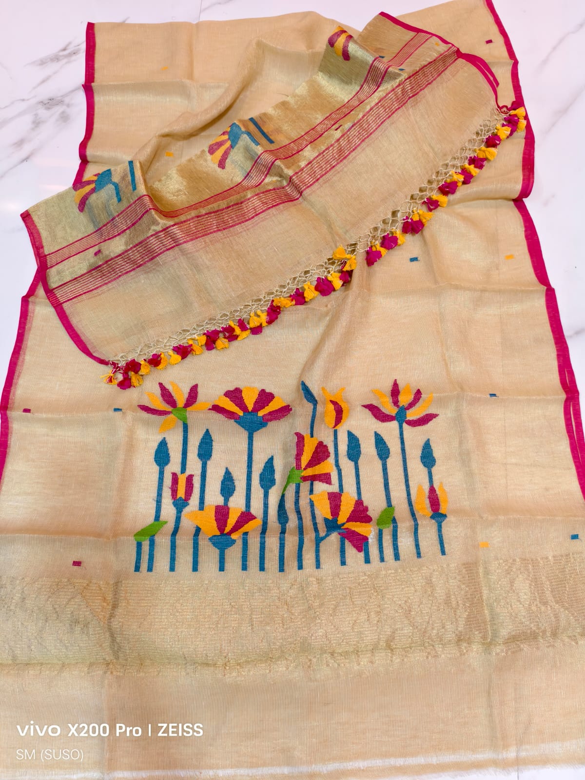 Tissue linen Pichwai weave Jamdani suit with dama detailing and zari palla, paired with floral-woven dupatta featuring zari border by Rihyaaz.