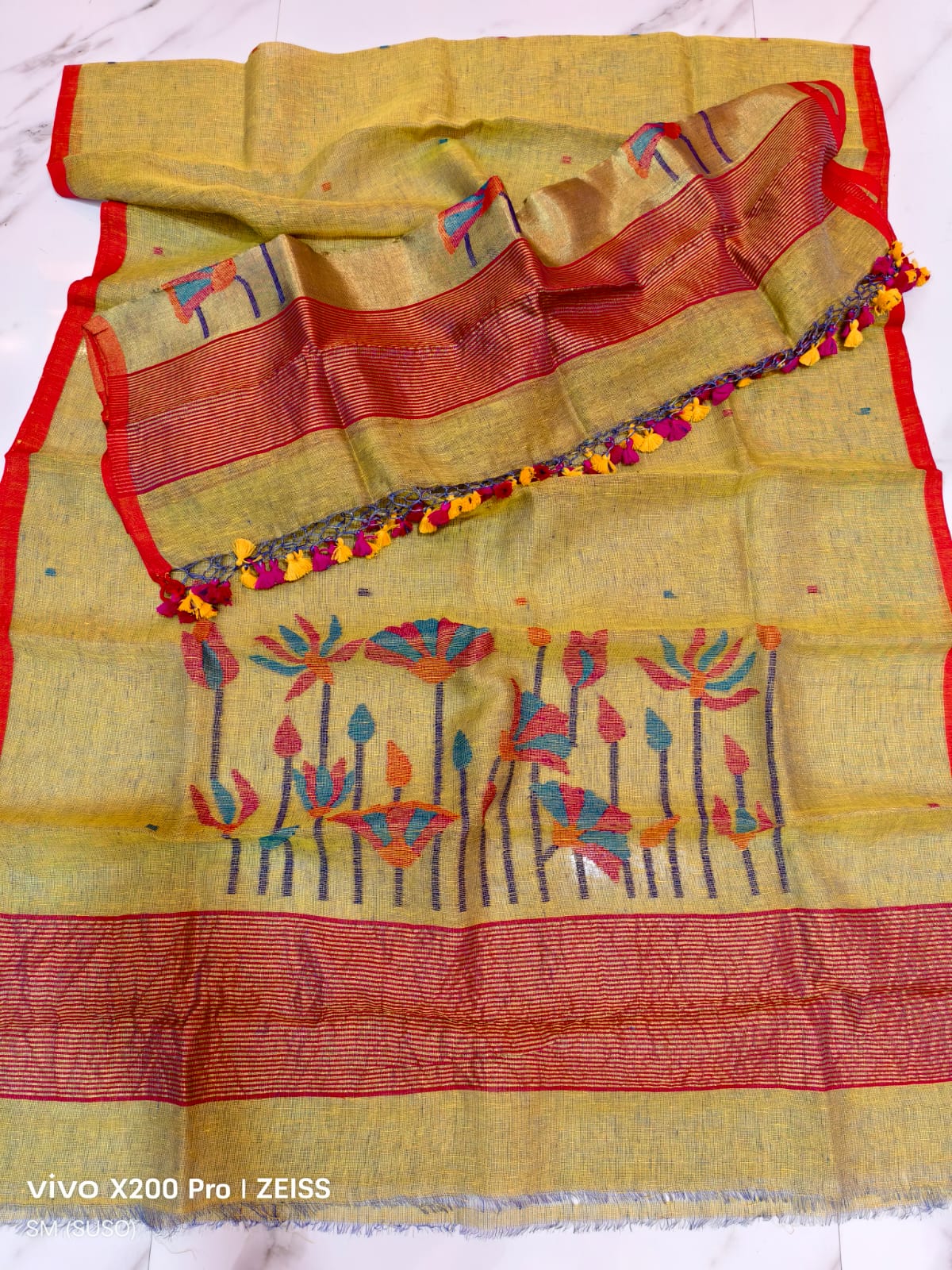 Tissue linen Pichwai weave Jamdani suit with dama detailing and zari palla, paired with floral-woven dupatta featuring zari border by Rihyaaz.