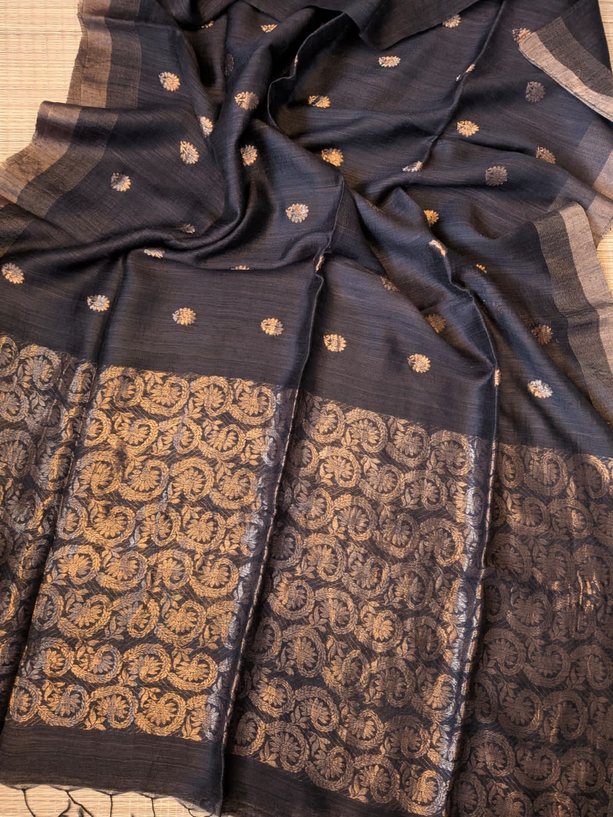 Black Festive Special premium-quality Matka saree featuring a beautiful Banarasi-pattern zari pallu, paired with a matching running Matka blouse piece. Silk Mark available. Elegant traditional saree for festive occasions, weddings, and celebrations by Rihyaaz.