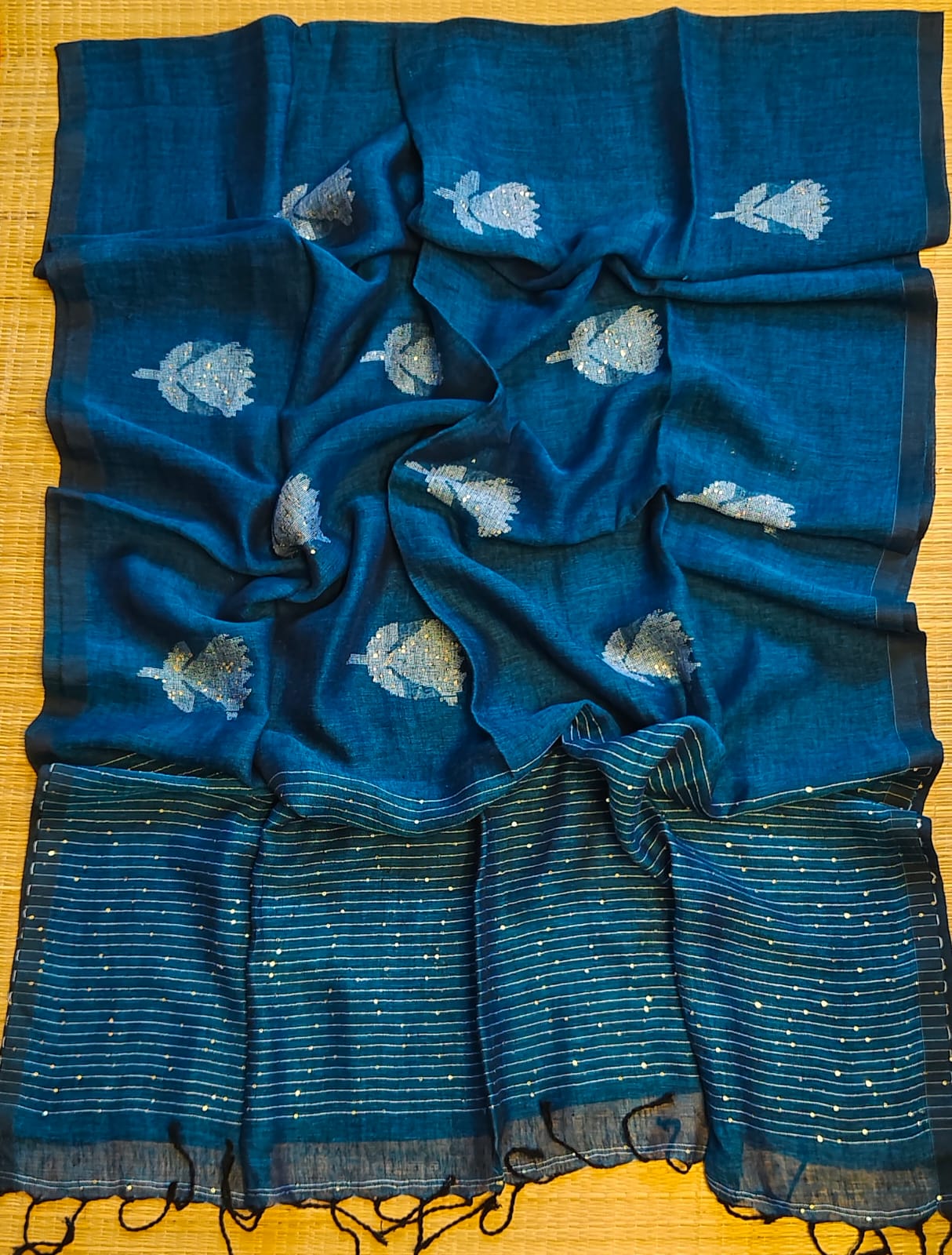 Shri Pure Linen by Linen handwoven floral motif Jamdani saree with sequence work on motifs and pallu, needlework butta and check blouse piece by Rihyaaz.