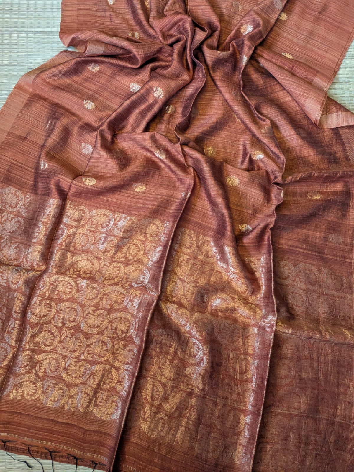 Bronze Festive Special premium-quality Matka saree featuring a beautiful Banarasi-pattern zari pallu, paired with a matching running Matka blouse piece. Silk Mark available. Elegant traditional saree for festive occasions, weddings, and celebrations by Rihyaaz.