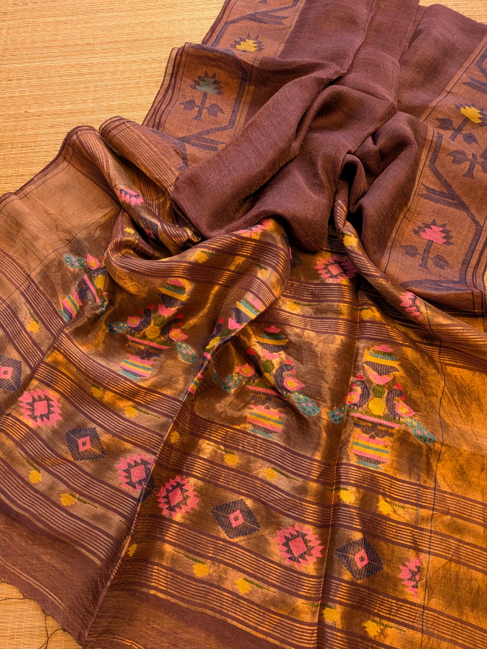 Iravati Dark brown exclusive silk linen saree featuring a tested zari Jamdani border, elegant Paithani-style tissue pallu, and matching running blouse piece by Rihyaaz Fashions.