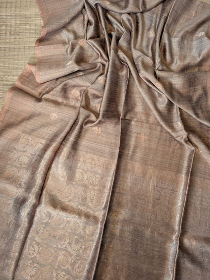 Brown Festive Special premium-quality Matka saree featuring a beautiful Banarasi-pattern zari pallu, paired with a matching running Matka blouse piece. Silk Mark available. Elegant traditional saree for festive occasions, weddings, and celebrations by Rihyaaz.