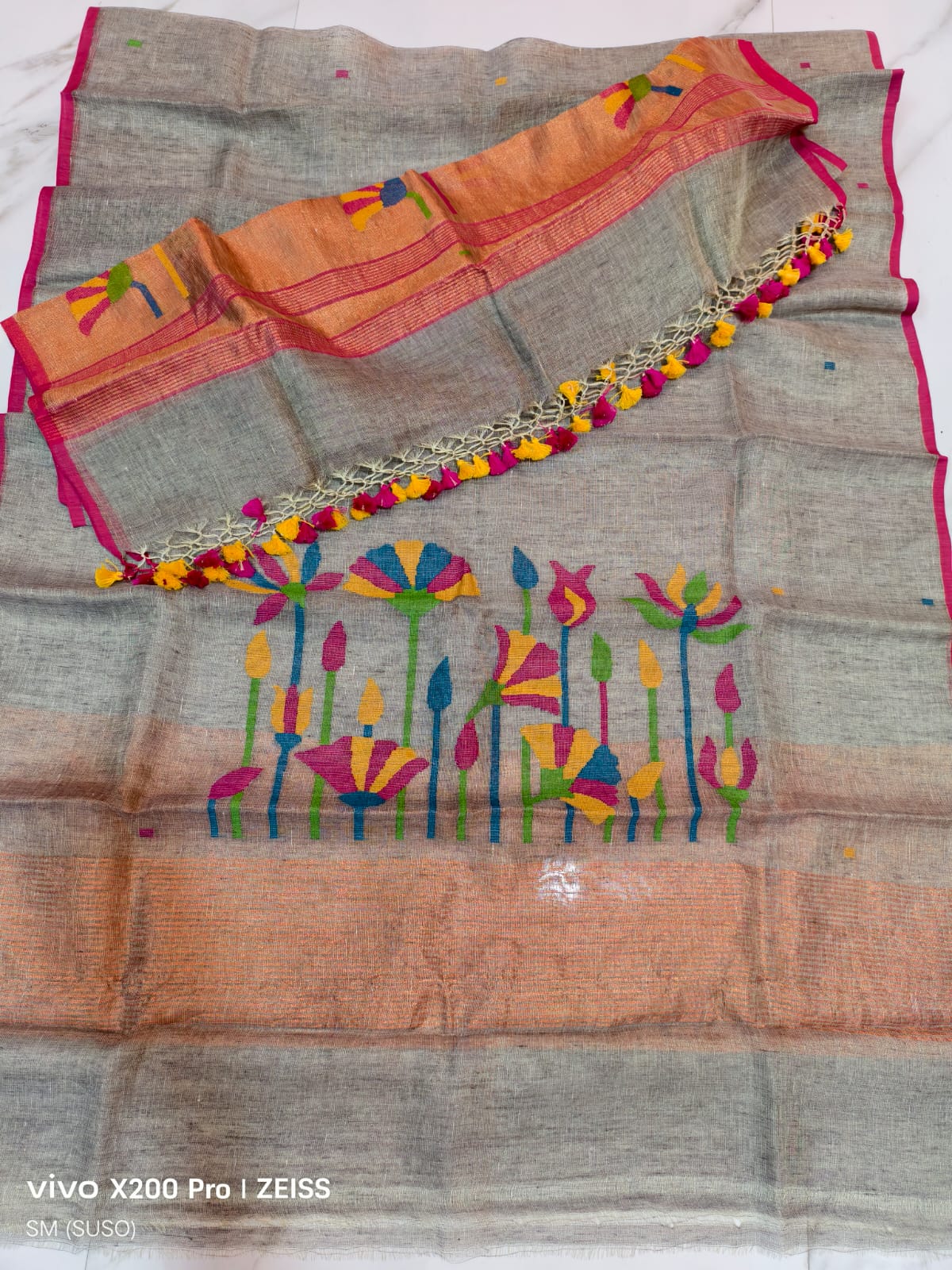 Tissue linen Pichwai weave Jamdani suit with dama detailing and zari palla, paired with floral-woven dupatta featuring zari border by Rihyaaz.