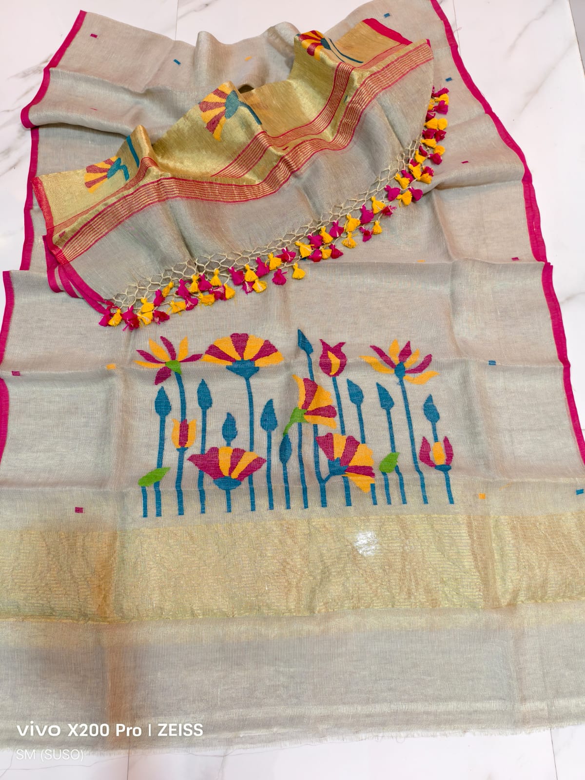 Tissue linen Pichwai weave Jamdani suit with dama detailing and zari palla, paired with floral-woven dupatta featuring zari border by Rihyaaz.