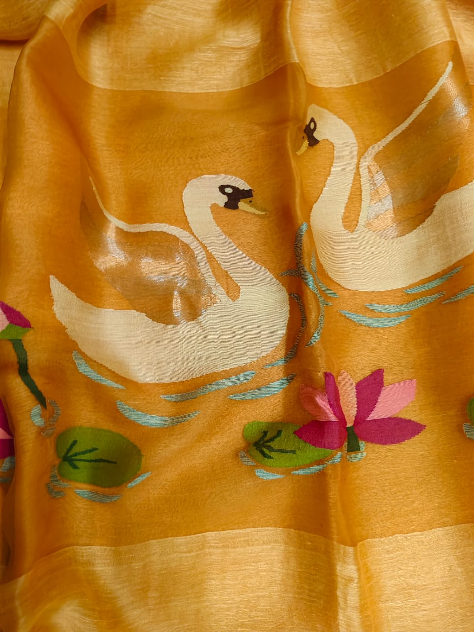 Embroidered fabric with swans and lotus flowers on a yellow background