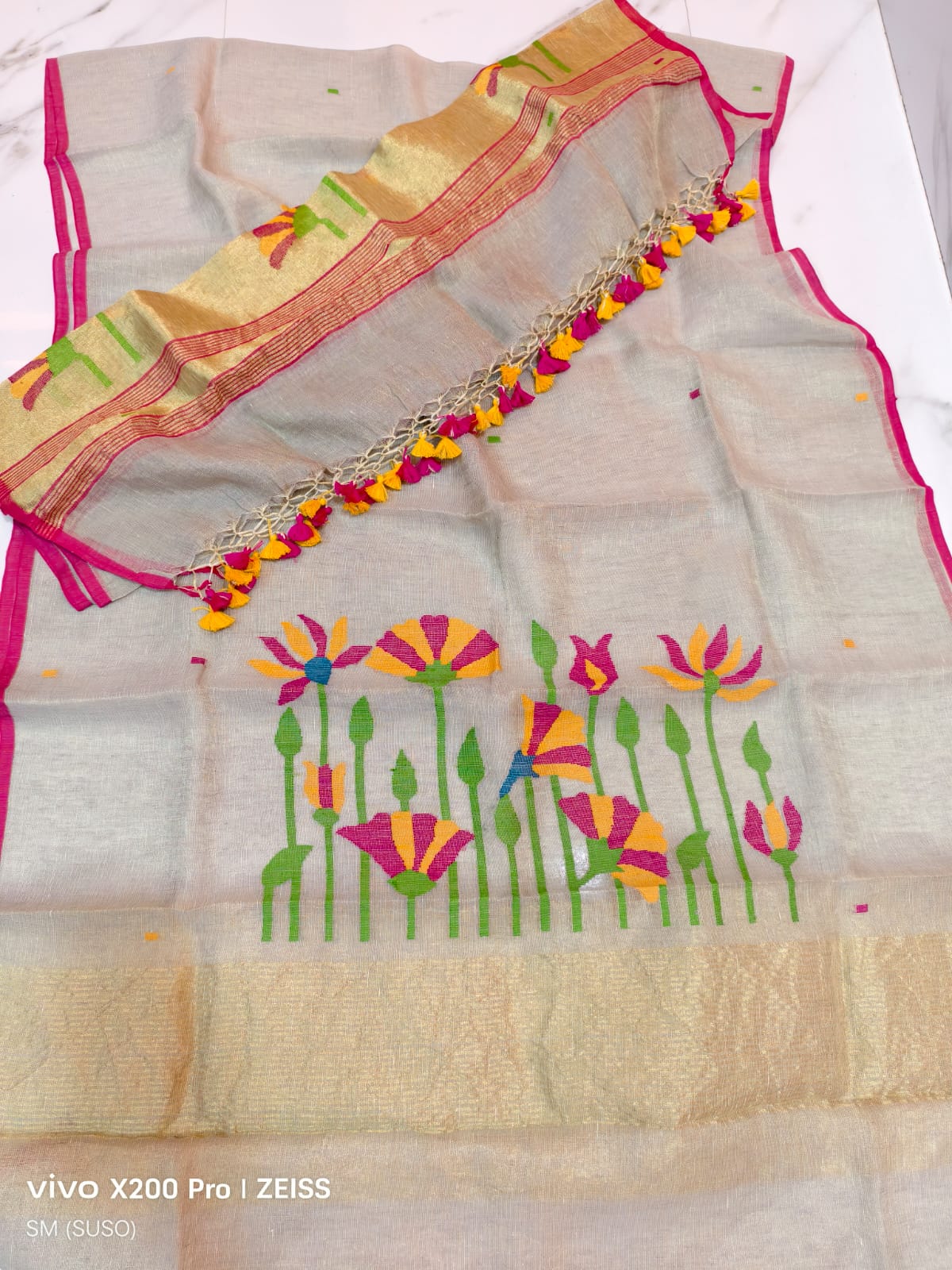 Tissue linen Pichwai weave Jamdani suit with dama detailing and zari palla, paired with floral-woven dupatta featuring zari border by Rihyaaz.