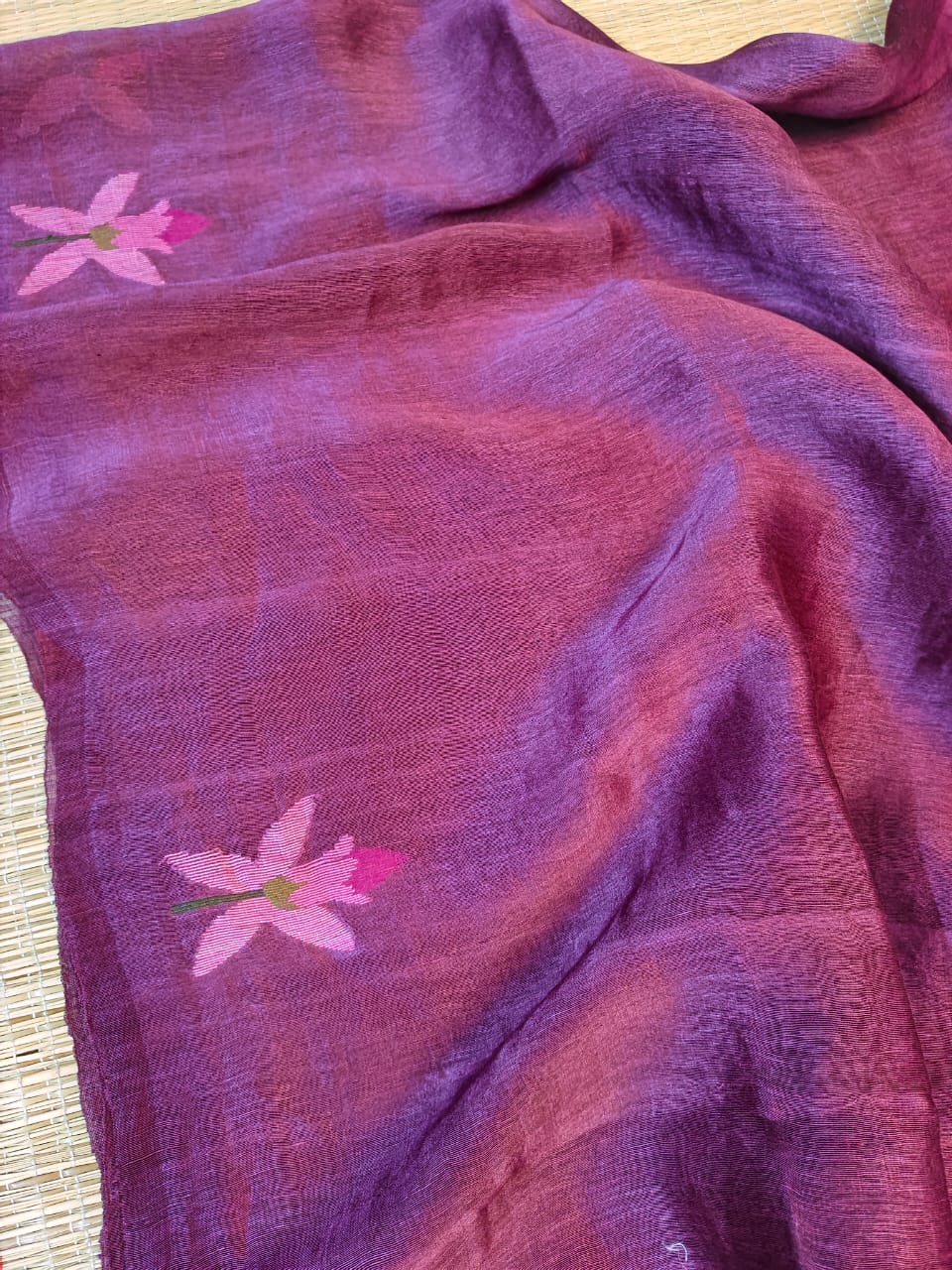 Purple fabric with pink floral patterns on a wooden surface