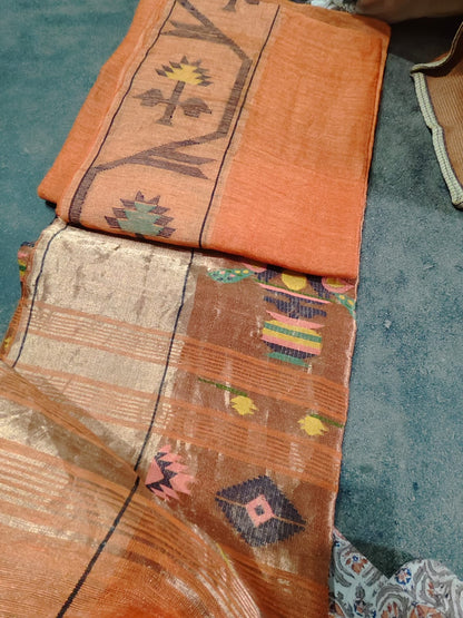 Iravati Orange exclusive silk linen saree featuring a tested zari Jamdani border, elegant Paithani-style tissue pallu, and matching running blouse piece by Rihyaaz Fashions.