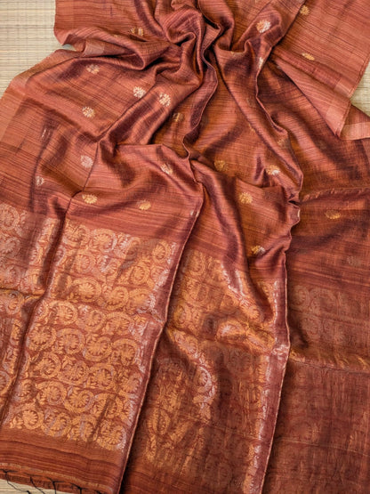 Teracotta Festive Special premium-quality Matka saree featuring a beautiful Banarasi-pattern zari pallu, paired with a matching running Matka blouse piece. Silk Mark available. Elegant traditional saree for festive occasions, weddings, and celebrations by Rihyaaz.