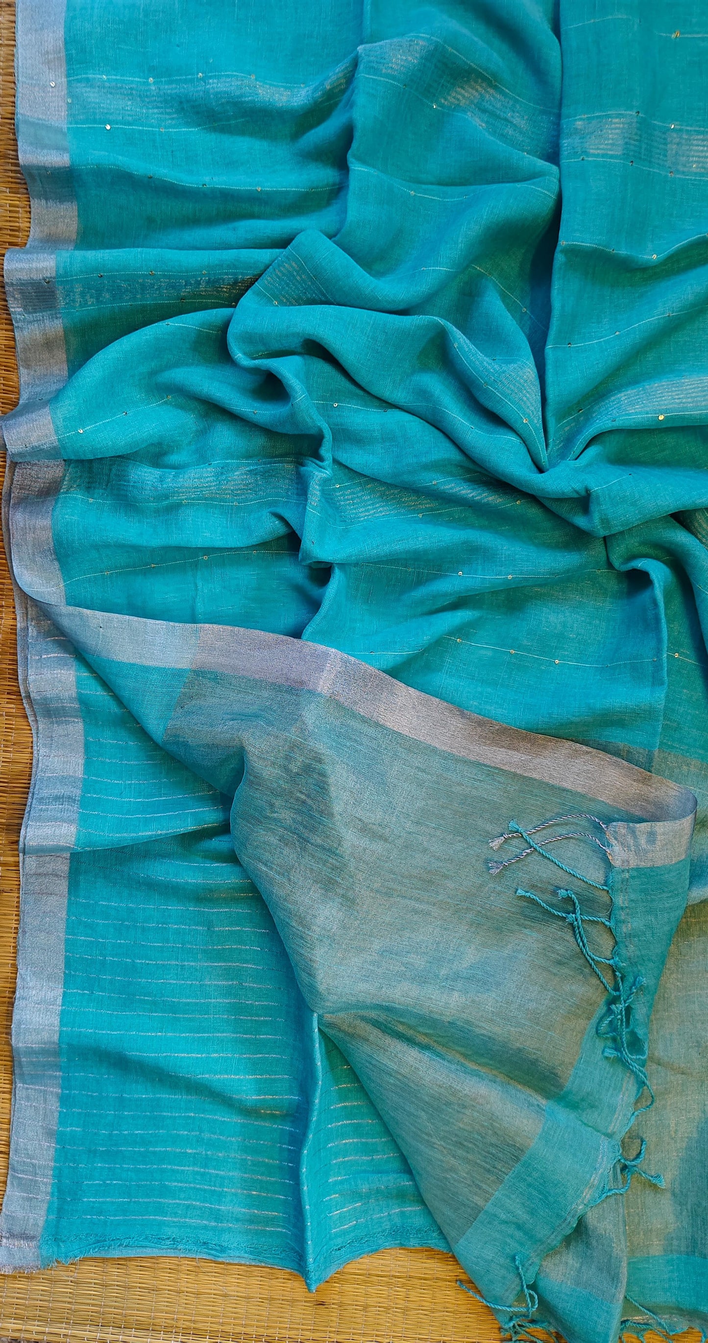 Pehal Premium Jayashree linen saree with tested zari pallu, sleek silver border, all-over sequin-line detailing and zari-striped blouse piece by Rihyaaz.
